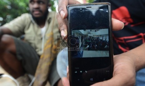 Mahasiswa Papua menunjukan foto rekannya melalui handphone genggam (ilustrasi).