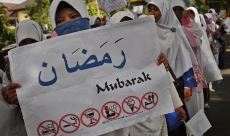  Seorang mahasiswi melakukan aksi simpatik sambut bulan Ramadhan di depan kantor Gubernur NTB, Mataram, Selasa (17/7). (Ahmad Subaidi/Antara)