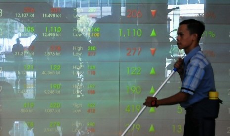 Seorang melintas di depan layar Grafik Indeks Harga Saham Gabungan (IHSG) di Bursa Efek Indonesia, Jakarta, Senin (4/8).