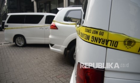 Seorang melintas disamping mobil sitaan milik bos First Travel yang merupakan tersangka untuk kasus penipuan dan penggelapan,pencucian uang serta pelanggaran Undang-undang Informasi dan trasnsaksi Elektronik (ITE), di halaman Bareskrim Polri, Jakarta, Senin (14/8). 