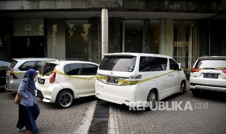 Seorang melintas disamping mobil sitaan milik bos First Travel yang merupakan tersangka untuk kasus penipuan dan penggelapan,pencucian uang serta pelanggaran Undang-undang Informasi dan trasnsaksi Elektronik (ITE), di halaman Bareskrim Polri, Jakarta, Senin (14/8)