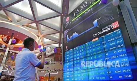 Seorang mengunjung memotret layar pergerakan Indeks Harga Saham Gabungan (IHSG) di Bursa Efek Indonesia, Jakarta, Jumat (28/6/2019).