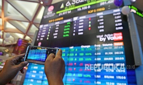 Seorang mengunjung memotret layar pergerakan Indeks Harga Saham Gabungan (IHSG) di Bursa Efek Indonesia, Jakarta, Jumat (28/6/2019). 