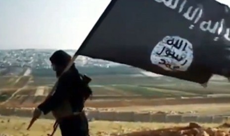 Seorang milisi membawa bendera kelompok teroris ISIS.