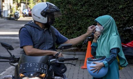 Seorang murid diantar orang tuanya saat hari pertama pembelajaran tatap muka (PTM) di SD Ar Rafi, Jalan Sekejati, Kiaracondong, Kota Bandung.