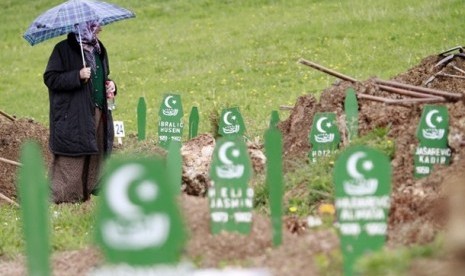 Seorang muslim Bosnia  berdiri menyaksikan makam korban perang Serbia.