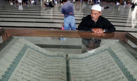 Seorang Muslim melihat Alquran raksasa