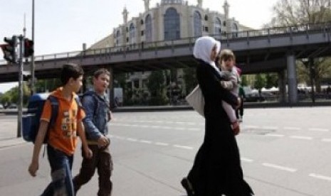 Seorang Muslimah melintas di jalan raya dengan latar belakang masjid Berlin (Ilustrasi)