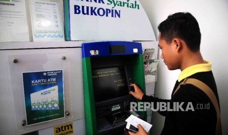 Seorang nasabah melakukan transaksi menggunakan mesin ATM Bank Bukopin Syariah, Jakarta, Ahad (17/4). (Republika/Agung Supriyanto)