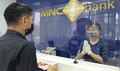 Seorang nasabah menabung di MNC Bank.