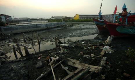 Seorang nelayan berdiri di atas kapalnya yang berada di wilayah pendangkalan muara kawasan Pelabuhan Tegal, Jawa Tengah, Rabu (5/1/2022). Menurut Himpunan Nelayan Seluruh Indonesia (HNSI) Jawa Tengah pendangkalan atau sedimentasi yang terjadi sejak 10 tahun terakhir tersebut berdampak pada puluhan kapal nelayan 5 GT kesulitan untuk melaut dan memasuki muara, sehingga berharap pemerintah setempat melakukan pengerukan.