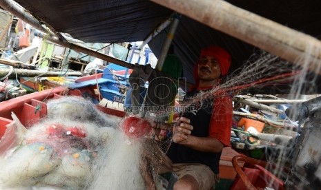  Seorang nelayan menata jaring diatas kapalnya di Pelabuhan Muara Angke, Jakarta Utara, Selasa(7/4).  (Republika/Raisan Al Farisi)