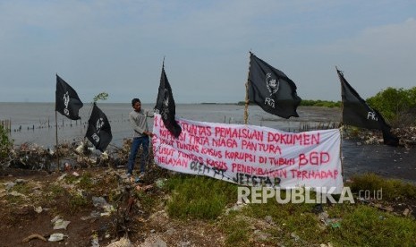  Seorang nelayan merapikan spanduk berisi penolakan pengerukan pasir di perairan Serang, Banten, Rabu (27/4). (Republika/Raisan Al Farisi)