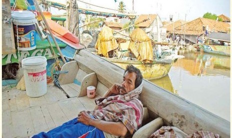 Seorang nelayan terlelap di kapalnya yang berlabuh di pantai utara daerah Eretan, Indramayu, Jawa Barat, Selasa (26/8).Akibat langka BBM jenis solar di jalur pantai utara,para nelayan tidak melaut.