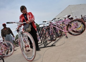 Seorang ofisial menggunakan sepeda fixie sebagai sarana transportasi alternatif SEA Games XXVI di kompleks Jakabaring Sport City, Palembang, Sumatera Selatan. 