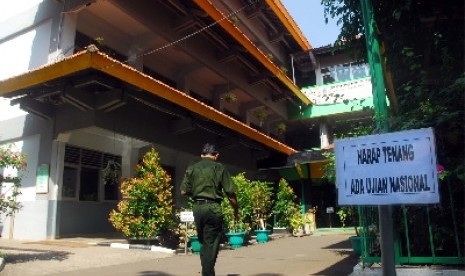 Seorang panitia Ujian Nasional (UN) melintas didepan Sekolah Menengah Kejuruan (SMK) Negeri 8 Jakarta saat UN berlangsung, Senin (16/4). 