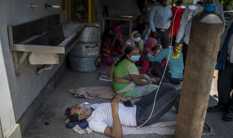 Seorang pasien menerima oksigen di luar Gurdwara, rumah ibadah Sikh, di New Delhi, India, Sabtu, 24 April 2021. Kekurangan oksigen medis di India menjadi begitu parah sehingga gurdwara ini mulai menawarkan sesi pernapasan gratis dengan tangki bersama untuk COVID-19 pasien menunggu ranjang rumah sakit.