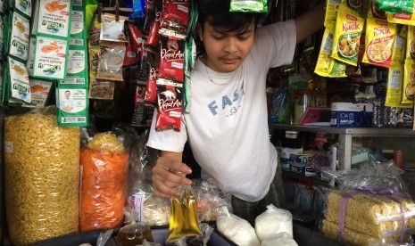 Seorang pedagang di Pasar Cikurubuk Kota Tasikmalaya menunjukkan minyak goreng curah yang masih dijual bebas di pasaran, Senin (7/10).