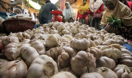 Seorang pedagang melayani pembeli bawang putih di pasar tradisional Inpres Lhokseumawe, Aceh. Senin (3/5/2019).