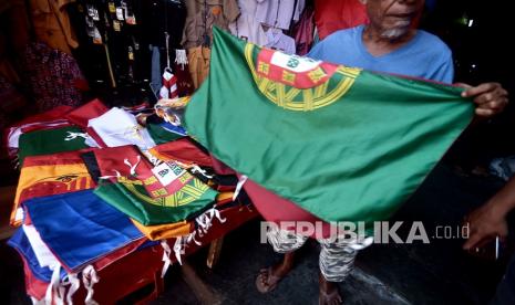 Seorang pedagang memperlihatkan bendera Portugal yang dijualnya di pusat perbelanjaan 45, Manado, Sulawesi Utara, Selasa (8/6/2021). Permintaan bendera negara-negara Eropa mengalami peningkatan jelang pelaksanaan Piala Eropa 2020 dan dijual dengan kisaran harga Rp65 ribu hingga Rp250 ribu tergantung ukuran. 