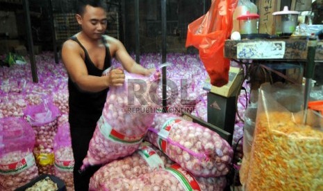 Seorang pedagang menimbang bawang putih di Pasar Induk Kramat Jati, Selasa (26/3).  (Republika/Wihdan Hidayat)