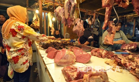 Seorang pedagang daging sapi melayani pembeli, di Pasar Kosambi, Kota Bandung, Senin (4/7). Pasca Lebaran harga daging sapi masih stabil Rp 130.000 ribu per kilogram. (Mahmud Muhyidin) 