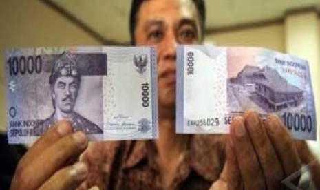 Seorang pegawai Bank Indonesia memperlihatkan contoh uang baru keluaran 2010 pecahan Rp10.000 di Kantor BI Makassar, Selasa (20/7). BI mengeluarkan uang baru keluaran 2010 pecahan Rp1000 (koin) dan Rp10.000 (kertas).