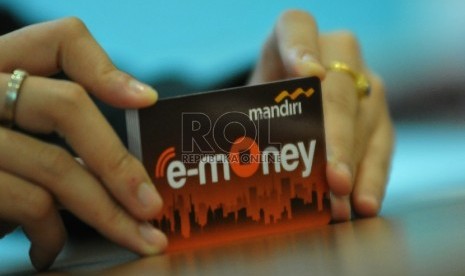 Seorang pegawai menunjukkan model layanan uang elektronik (E-Money) berbentuk kartu dari Bank Mandiri, di Jakarta, Selasa (51/7). Bank Indonesia terus mendorong penggunaan e-money sebagai pengganti uang tunai untuk lebih mudah mengontrol peredaran uang kar