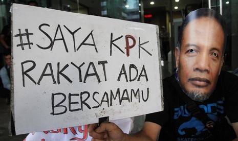  Seorang pegiat anti korupsi mengenakan topeng Wakil Ketua Komisi Pemberantasan Korupsi (KPK) Bambang Widjojanto saat puluhan aktivis menggelar aksi di Gedung KPK, Jakarta, Sabtu (24/1). (Antara/Akbar Nugroho Gumay)