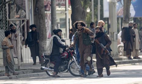 Seorang pejuang Taliban membantu salah satu yang terluka dalam insiden ledakan untuk melarikan diri dari lokasi ledakan, di Kabul, Afghanistan, Jumat, 23 September 2022. Taliban Eksekusi Mati Pelaku Pembunuhan di Depan Publik, Perdana Sejak Pengambilalihan