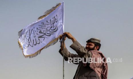  Seorang pejuang Taliban mengibarkan bendera mereka di atas kendaraan saat mereka berpatroli di Kandahar, Afghanistan, 17 Agustus 2021. Salah satu pendiri Taliban Abdul Ghani Baradar, pada 16 Agustus, menyatakan kemenangan dan mengakhiri perang puluhan tahun di Afghanistan, sehari setelahnya. pemberontak memasuki Kabul untuk menguasai negara.