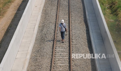 Seorang pekerja berjalan ditengah jalur rel kereta api Bandara Adi Soemarmo di Ngemplak, Boyolali, Jawa Tengah, Rabu (14/8/2019).