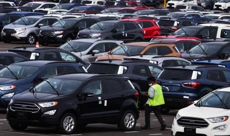 Seorang pekerja India berjalan di antara mobil Ford yang diparkir di pabrik Ford India yang terletak di Chengalpattu, sekitar 50 km selatan Chennai, India, 13 September 2021.