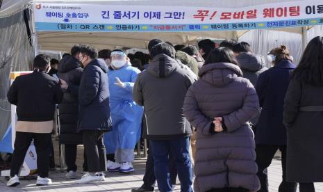 Seorang pekerja medis memandu orang-orang saat mereka menunggu tes virus corona di tempat pengujian darurat di Seoul, Korea Selatan, Jumat, 28 Januari 2022. Korea Selatan (Korsel) pada Jumat memperpanjang pembatasan COVID-19 selama dua pekan saat kasus infeksi varian Omicron melonjak. 