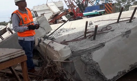 Seorang pekerja melihat konstruksi bangunan Proyek Strategis Nasional (PSN) Tol Pasuruan  Probolinggo (Paspro) yang ambruk di Desa Cukurgondang, Grati, Pasuruan, Ahad (29/10). 