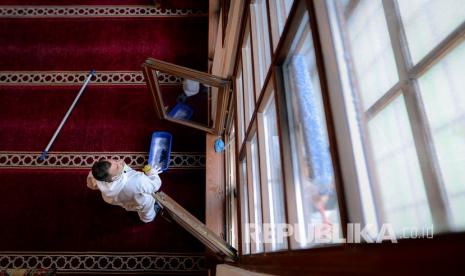 Seorang pekerja memberikan disinfektan di area masjid. Klaster dari kegiatan keagamaan harus menjadi perhatian khusus. Satgas Penanganan Covid-19 bahkan mencatat kegiatan takziah sangat berpotensi sebagai klaster penyebaran Covid-19.