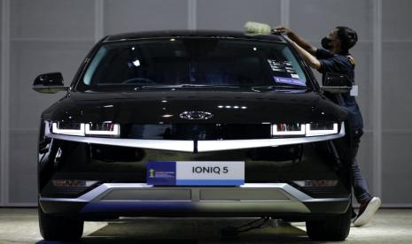 Seorang pekerja membersihkan mobil listrik Hyundai IONIQ 5 saat Indonesia International Motor Show di Jakarta, Indonesia, 16 Februari 2023.