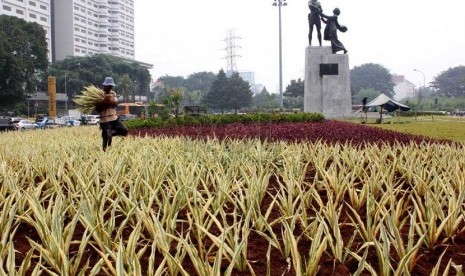  Seorang pekerja melakukan perawatan taman Tugu Tani, Jakarta Pusat, Senin (17/3). (foto : Raisan Al Farisi)