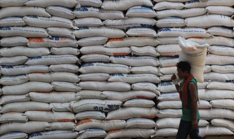 Seorang pekerja mengangkut beras di gudang beras Bulog, Jl Gedebage, Kota Bandung, Selasa (29/3). 