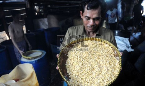  Seorang pekerja mengangkut biji kedelai yang telah direbus untuk dibuat tempe di Utan Panjang, Jakarta, Kamis (31/1).  (Republika/Aditya Pradana Putra)