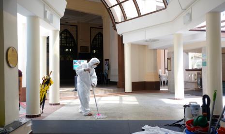 20 Masjid Singapura Tetapkan Kuota Jamaah Sholat Jumat. Seorang pekerja mengenakan pakaian pelindung (hazmat) dan masker mengepel lantai di Masjid Hajjah Fatimah di Singapura, Jumat (13/3). Singapura membuka ruang shalat terbatas untuk jamaah pekerja di sejumlah masjid terkait wabah corona.