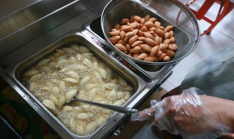 Seorang pekerja menggoreng panada tore di Kota Gorontalo, Gorontalo. Kudapan ini terbuat dari adonan tepung dengan isian abon ikan. Menjelang Lebaran, permintaan kue kering meningkat. (ilustrasi).