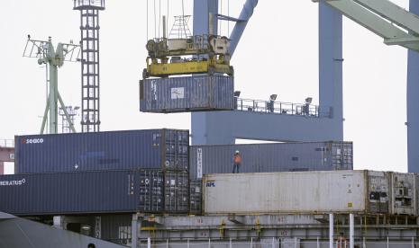 Seorang pekerja menyaksikan bongkar muat peti kemas di Pelabuhan Tanjung Priok, Jakarta, Selasa (24/8). Presiden Joko Widodo bertekad menghentikan ekspor bahan mentah dan komoditas harus diolah menjadi barang jadi. Untuk hal tersebut, dibutuhkan kesiapan industri.