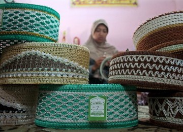 Seorang pekerja menyelesaikan pembuatan peci di Dusun Bedukan, Pleret, Bantul, Yogyakarta, Selasa (26/7). Mendekati Ramadhan, produksi peci yang dijual dengan harga Rp 7.000 hingga 17.000 meningkat hingga 200 %. 