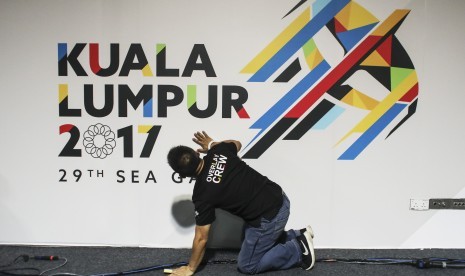 Seorang pekerja menyiapkan baligo SEA Games 2017 di media center di Kuala Lumpur, Malaysia, Jumat (11/8). 