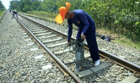  Seorang pekerja tengah melakukan perawatan rel kereta api. 