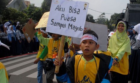 Seorang pelajar Sekolah Alam Indonesia membawa poster bertuliskan ''Aku Bisa Puasa Sampai Magrib'' saat mengikuti Pawai Tarhib Ramadan di Sukabumi, Jawa Barat, Rabu (24/5). 