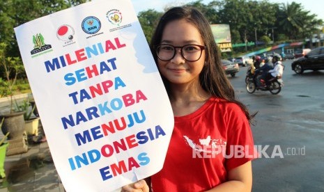 Seorang pelajar sekolah memperlihatkan poster ajakan millenial sehat tanpa narkoba saat berkampanye memperingati Hari Anti Narkotika Internasional (HANI) di Bundaran Digulis Pontianak, Kalimantan Barat, Rabu (26/6/2019).