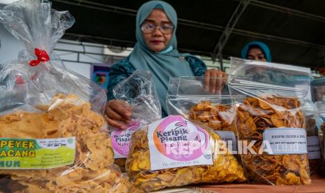 Seorang pelaku usaha kecil menata aneka produknya pada Pameran Produk UMKM. ilustrasi