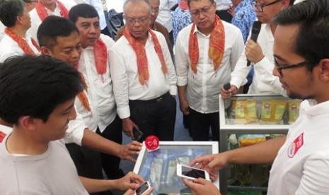 Seorang pelanggan melakukan transaksi pembelian barang menggunakan layanan TCASH-BTPN Wow! disaksikan oleh  Direktur Utama Telkomsel Ririek Adriansyah, Direktur Program Elektronifikasi dan Inklusi Keuangan BI Pungky Purnomo Wibowo, Kepala Eksekutif Pengawas Perbankan OJK Nelson Tampubolon, dan Dirjen Penanganan Fakir Miskin Kemsos Andi Zainal Abidin.